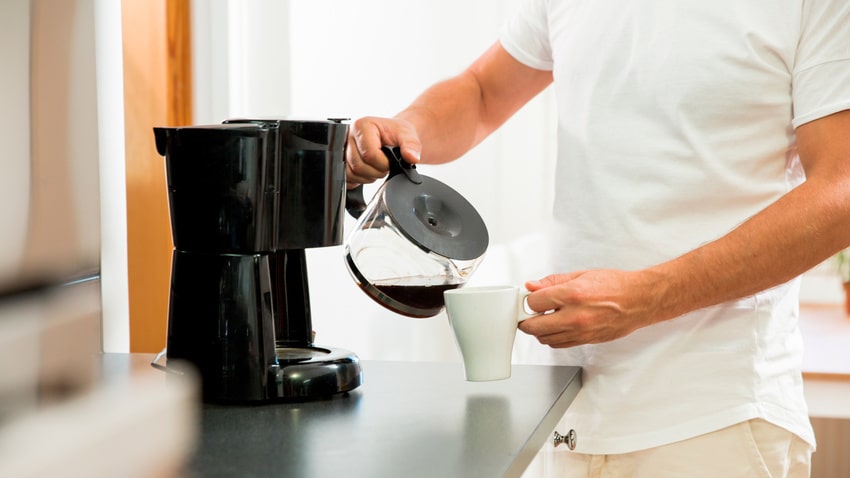 コーヒーをカップに注ぐ男性